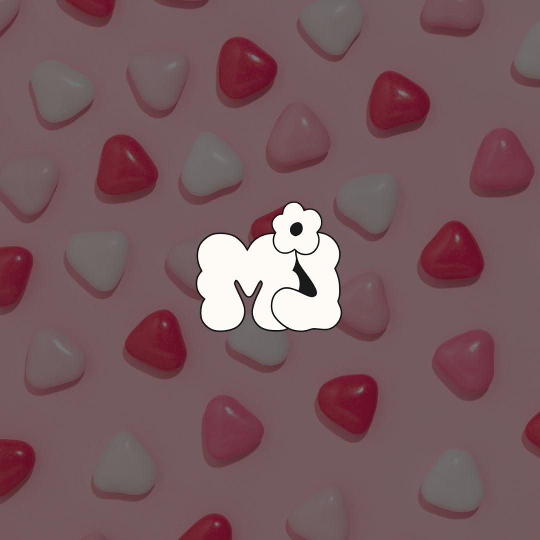 Petits bonbons de St-Valentin sur fond rose avec le logo Mel Jannard à l'avant-plan